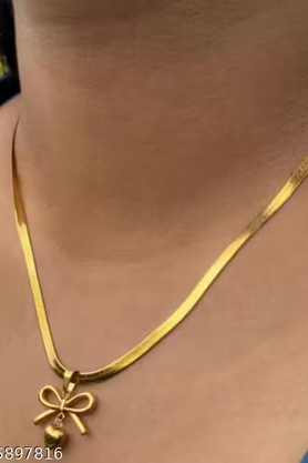 Gold-tone bow and heart pendant necklace on display bust