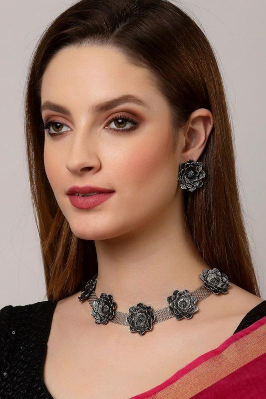 Floral oxidised silver-tone necklace and matching earrings on model