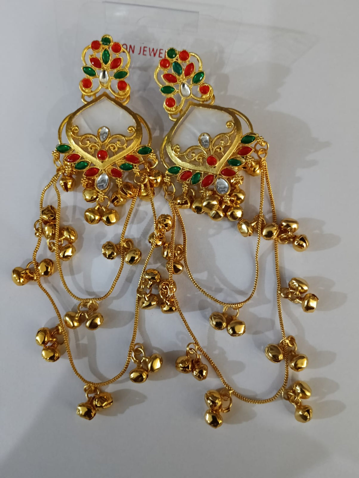 White red and green traditional long jhumka earrings in product packaging