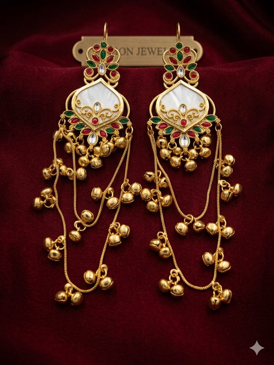 White red and green traditional jhumka earrings displayed on a red velvet background