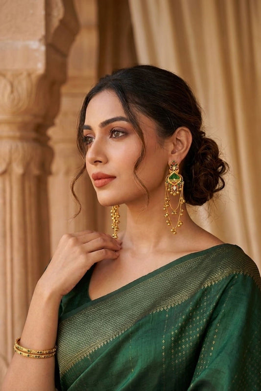 Green red and gold traditional jhumka earrings styled with a green saree