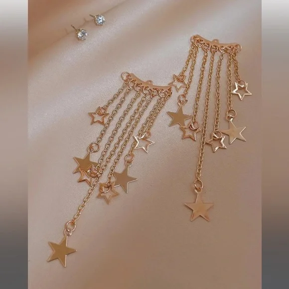 Gold-tone star chain earrings on blue box