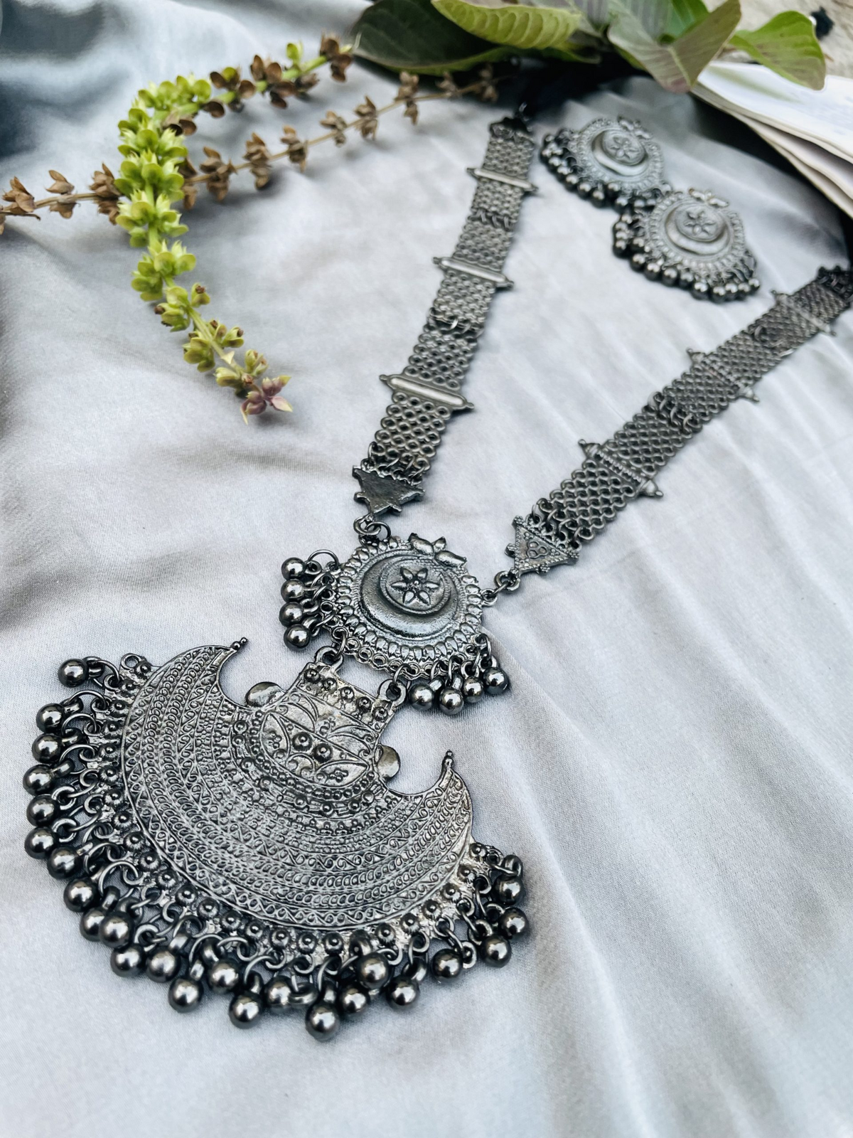 Oxidised silver-tone crescent pendant necklace set styled on fabric